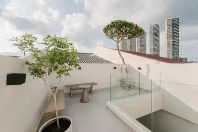 a balcony with a table and trees on a building at Mint Villa with Jacuzzi Pool in George Town