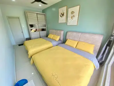 a bedroom with two beds with yellow sheets at Decozy7.0 Ipoh Town Condo(12pax) in Ipoh