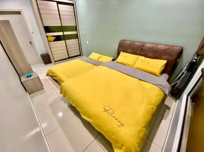 a bed with yellow sheets and pillows in a room at Decozy7.0 Ipoh Town Condo(12pax) in Ipoh