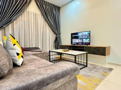 a living room with a couch and a tv at Decozy7.0 Ipoh Town Condo(12pax) in Ipoh