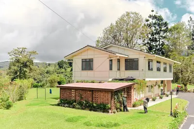 a house with people standing in front of it at Rose Cottage by De'La Ferns in Tanah Rata