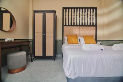 a bedroom with two beds and a desk and a mirror at Rose Cottage by De'La Ferns in Tanah Rata