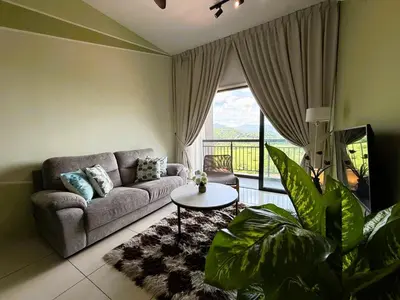 a living room with a couch and a table at The Horizon Ipoh Emerald by Grab A Stay in Ipoh