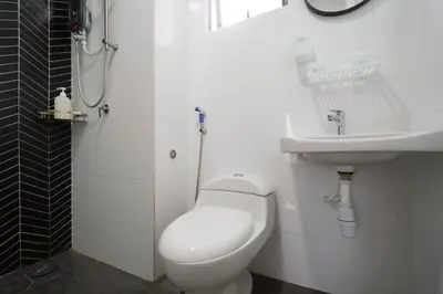 a white bathroom with a toilet and a sink at The Horizon Ipoh Emerald by Grab A Stay in Ipoh