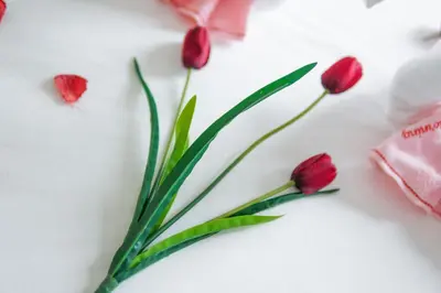 a bunch of red tulips on a table with pink ribbon at The Horizon Ipoh Emerald by Grab A Stay in Ipoh