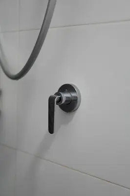 a shower nozzle on a white tiled wall at The Horizon Ipoh Emerald by Grab A Stay in Ipoh