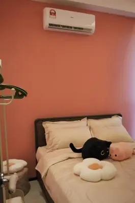 a black cat sitting on top of a bed at Urban Suites 3 Rooms, Cat Theme & Romantic in Jelutong