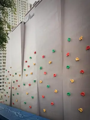 a climbing wall with umbrellas on the side of a building at Urban Suites 3 Rooms, Cat Theme & Romantic in Jelutong