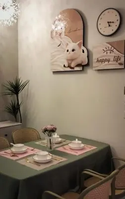 a table with a happy life picture and a clock at Urban Suites 3 Rooms, Cat Theme & Romantic in Jelutong