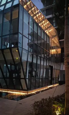 a glass building with lights in front of it at Romantic Sea View Room @ Urban Suites, Jelutong in Jelutong