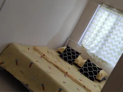 a bedroom with a bed with a comforter and pillows at Barakah Sufi Home Stay Apartment Cameron in Tanah Rata