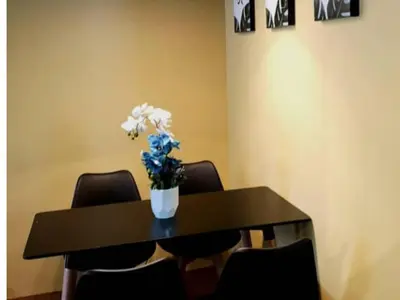 a black table with a vase of flowers on it at Barakah Sufi Home Stay Apartment Cameron in Tanah Rata