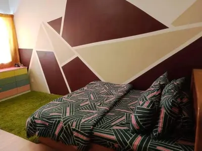 a bedroom with a bed with a geometric wall at Barakah Sufi Home Stay Apartment Cameron in Tanah Rata