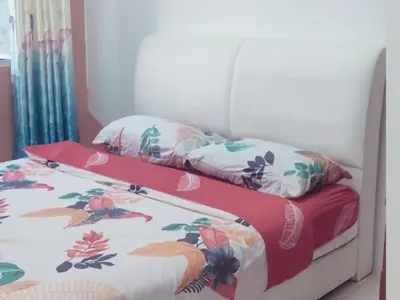 a bedroom with two twin beds with floral sheets at Barakah Sufi Home Stay Apartment Cameron in Tanah Rata