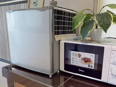 a microwave sitting on a table next to a plant at Barakah Sufi Home Stay Apartment Cameron in Tanah Rata