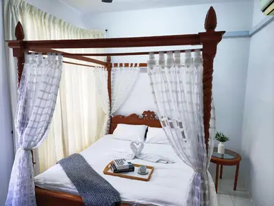 a bedroom with a canopy bed with a tray on it at IPOH Chemor Casa Klebang, 5 PAX Fully Air-Con Homestay in Chemor