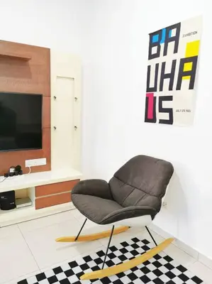 a chair sitting in a living room with a tv at IPOH BOTANI bauhaus 17pax/4BR/mahjong/tv box in Ipoh