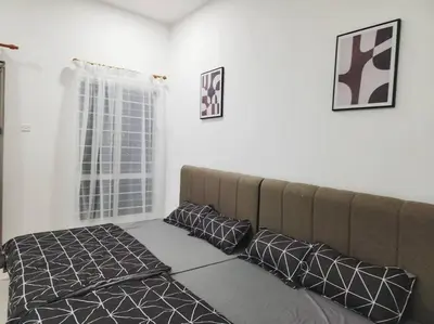 a bed in a room with a couch and pillows at IPOH BOTANI bauhaus 17pax/4BR/mahjong/tv box in Ipoh