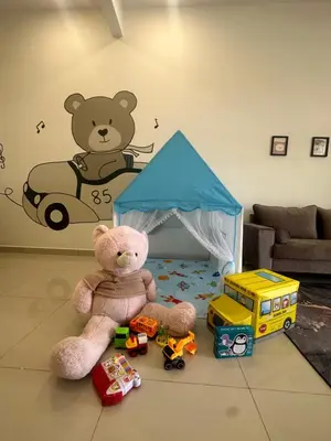 a teddy bear and toys on the floor in a room at Pantai Remis Bear Homestay in Pantai Remis