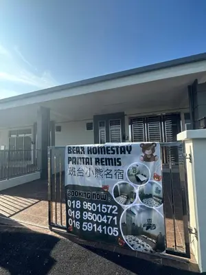 a sign on a fence in front of a building at Pantai Remis Bear Homestay in Pantai Remis