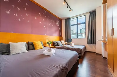 two beds in a room with birds on the wall at Serene Nova Family Retreat (2-6pax)near Kea Farm Market in Brinchang