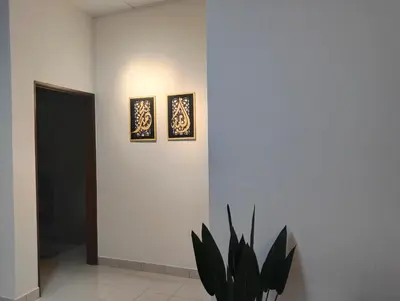a room with two pictures on the wall and a plant at UR Homestay, Seri Iskandar in Seri Iskandar