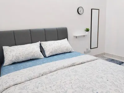 a bedroom with a bed with a clock on the wall at UR Homestay, Seri Iskandar in Seri Iskandar