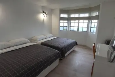 two beds in a room with two windows at Silverpar B5-5-1 Mountain View(walk up 2 floor up) in Bukit Fraser
