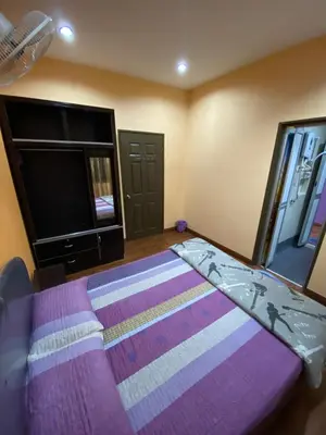 a bedroom with a bed and a flat screen tv at Frosty Hills Homestay in Tanah Rata