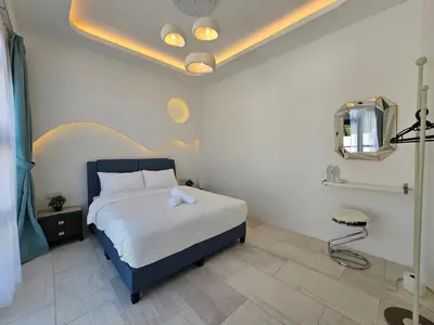 a bedroom with a bed with a blue headboard at Ipoh Young Villa - Hotel Inspired in Ipoh