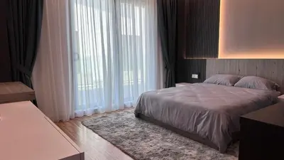 a bedroom with a large bed and large windows at Grand’e La Villa Homestay in Lumut