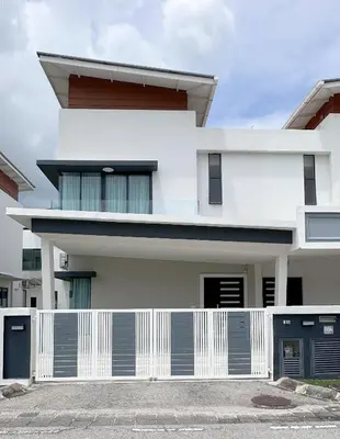 a white house with a fence in front of it at Grand’e La Villa Homestay in Lumut