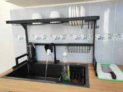 a kitchen sink with water coming out of it at Cozy Roomstay Padang Serai in Padang Serai