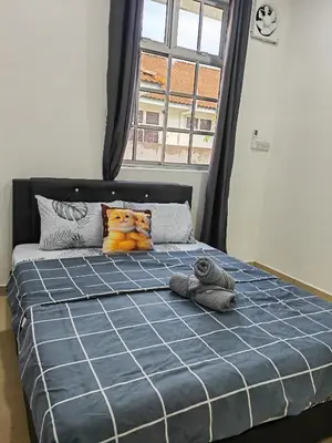 a bed with a teddy bear pillow and a window at Cozy Roomstay Padang Serai in Padang Serai