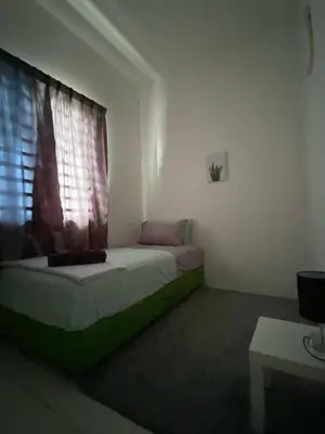 a small bedroom with a bed and a window at Abu Fateh Homestay in Seri Iskandar