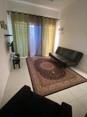 a living room with a couch and a rug at Abu Fateh Homestay in Seri Iskandar