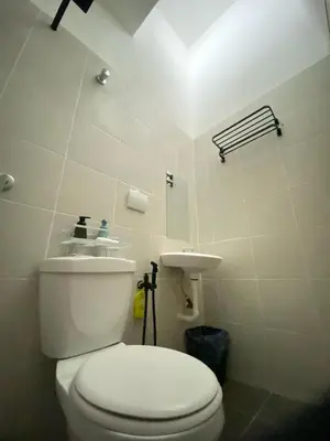 a bathroom with a white toilet and a sink at Abu Fateh Homestay in Seri Iskandar