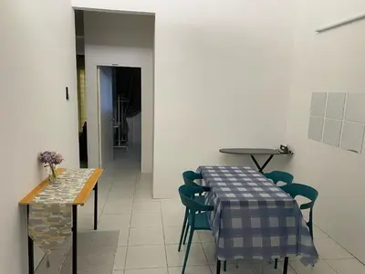 a dining room with a table and chairs at Abu Fateh Homestay in Seri Iskandar