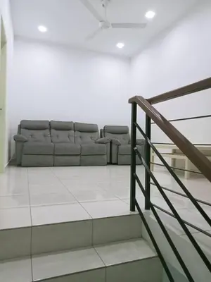 a living room with a couch and a staircase at MR OT HOMESTAY ( BAITUL RAUDHAH ) in Kepala Batas