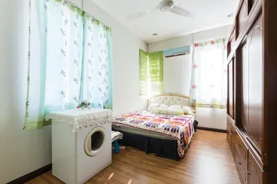 a bedroom with a bed and a washing machine at Cosy HomeStay at Penang Island -Beach and Village in Bayan Lepas