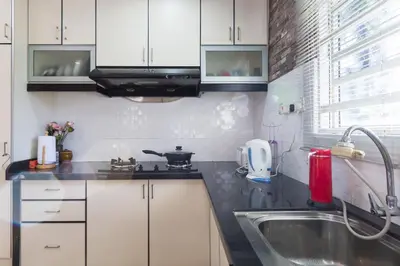 a kitchen with white cabinets and a sink at Cosy HomeStay at Penang Island -Beach and Village in Bayan Lepas