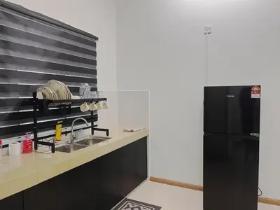 a kitchen with a sink and a black refrigerator at MamaShy Homestay Manjung -FREE WIFI- in Seri Manjung