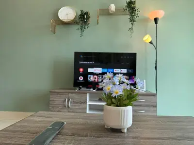 a vase of flowers sitting on a table in front of a tv at 【NEW】Harmony’s Home@Juru Sentral Icon City in Bukit Mertajam