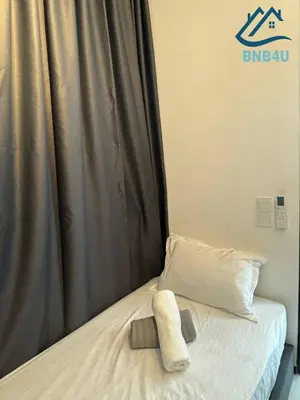 a bed with a pillow on it next to a curtain at Urban Suites @ George Town Penang by BNB4U in George Town
