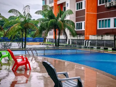 a swimming pool with two chairs in front of a building at Pavilionvillie M1T692 by irainbow in Ipoh