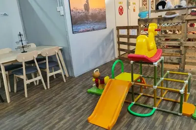 a play room with a table and chairs and a slide at Kitty Home Near to Penang Hill in Ayer Itam