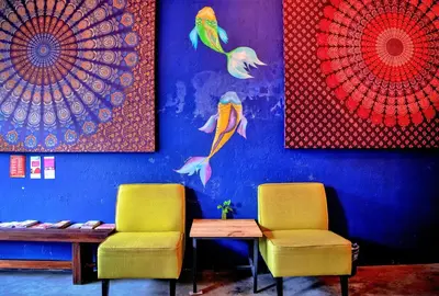 two chairs and a table in a room with paintings at Rope Walk Guest House in George Town
