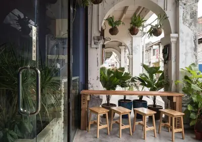 a table and four stools in a room with plants at Rope Walk Guest House in George Town