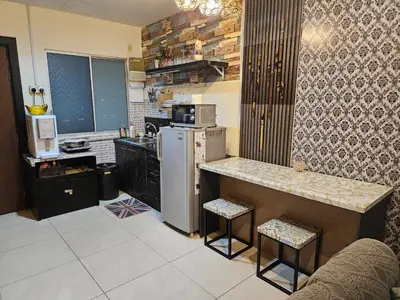 a kitchen with a refrigerator and a counter with stools at Tower Homestay @ Muslim Friendly in Ipoh
