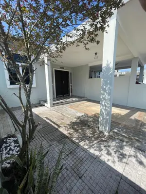 a white building with a tree in the courtyard at D' Permata Homestay Kulim in Kulim